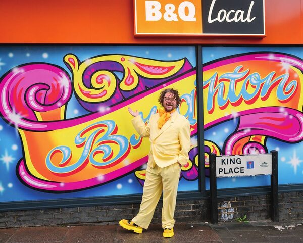 A man in yellow in front of the B&Q Local Brighton mural